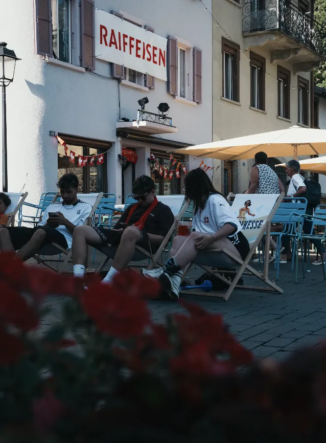 Junge Leute entspannen in Liegestühlen auf dem Rathausplatz an einem Sommertag